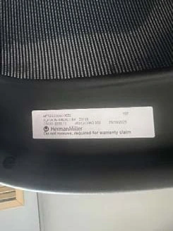 Second example of the manufacturing label under a Herman Miller chair seat with the notice not to remove it